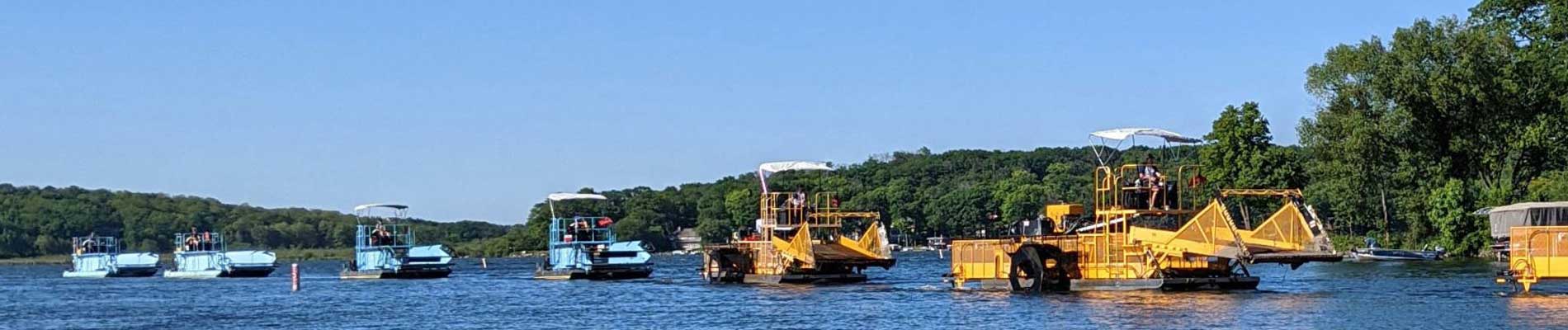 Parade on water of Aquarius Systems weed harvester and transport barges.